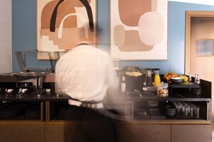 A kitchen area with a counter, various kitchen appliances, and a display of fruits and condiments.