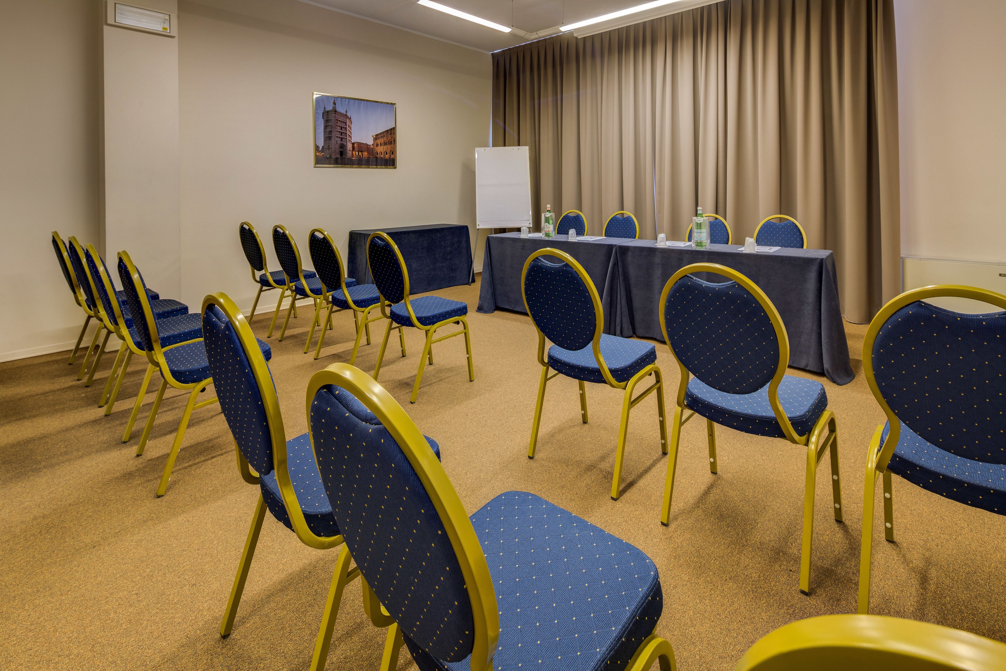 Une salle de conférence avec une longue table et des chaises disposées pour une réunion.