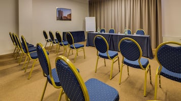 Une salle de conférence avec une longue table et des chaises disposées pour une réunion.