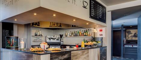 A modern bar area with a coffee machine, shelves of bottles, and a menu board.