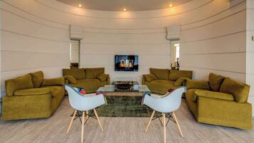 Uma sala de estar moderna com dois sofás, uma mesa de centro de vidro e uma lareira.