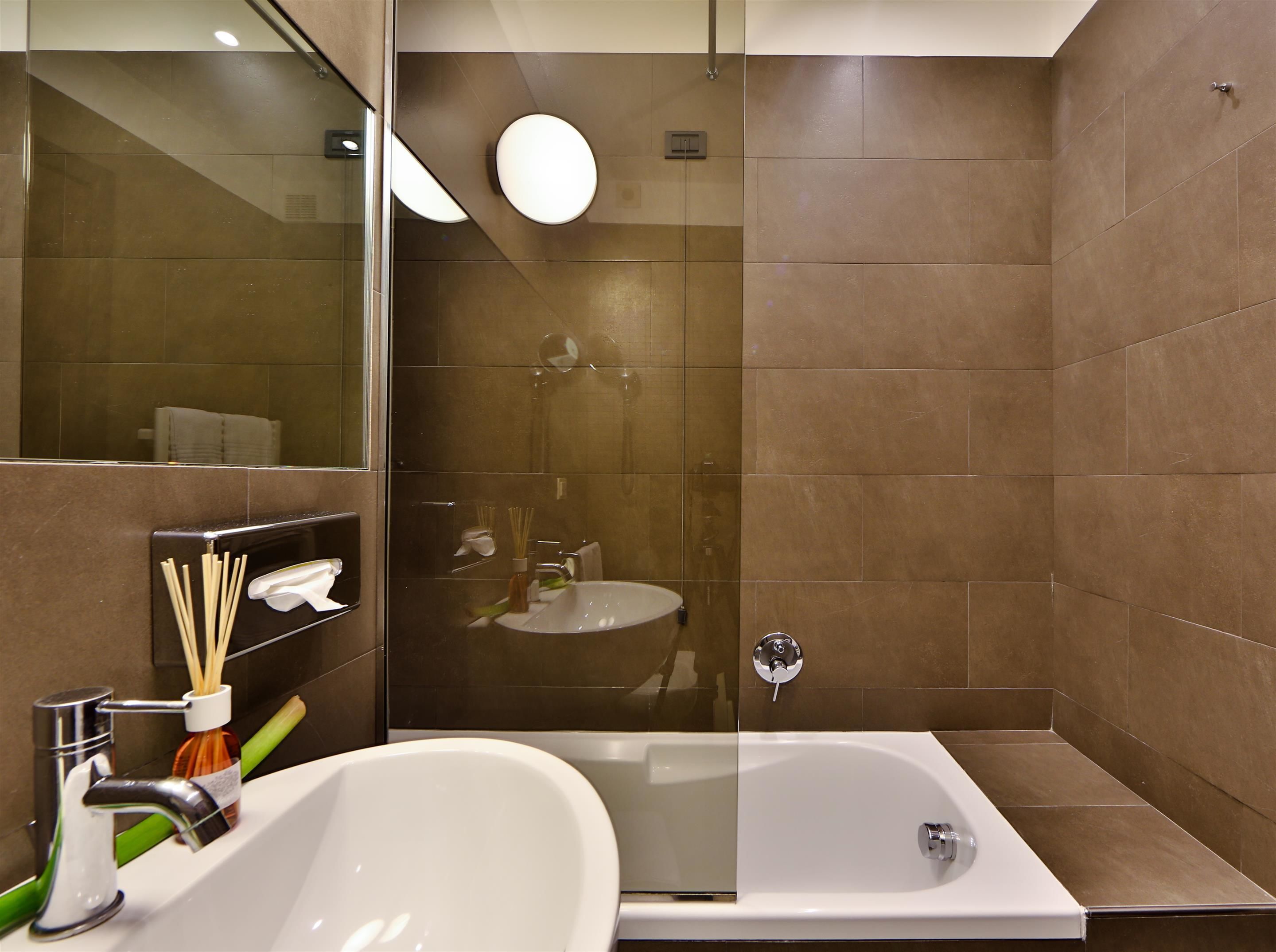A modern bathroom with a bathtub, a sink, and a glass-enclosed shower area.