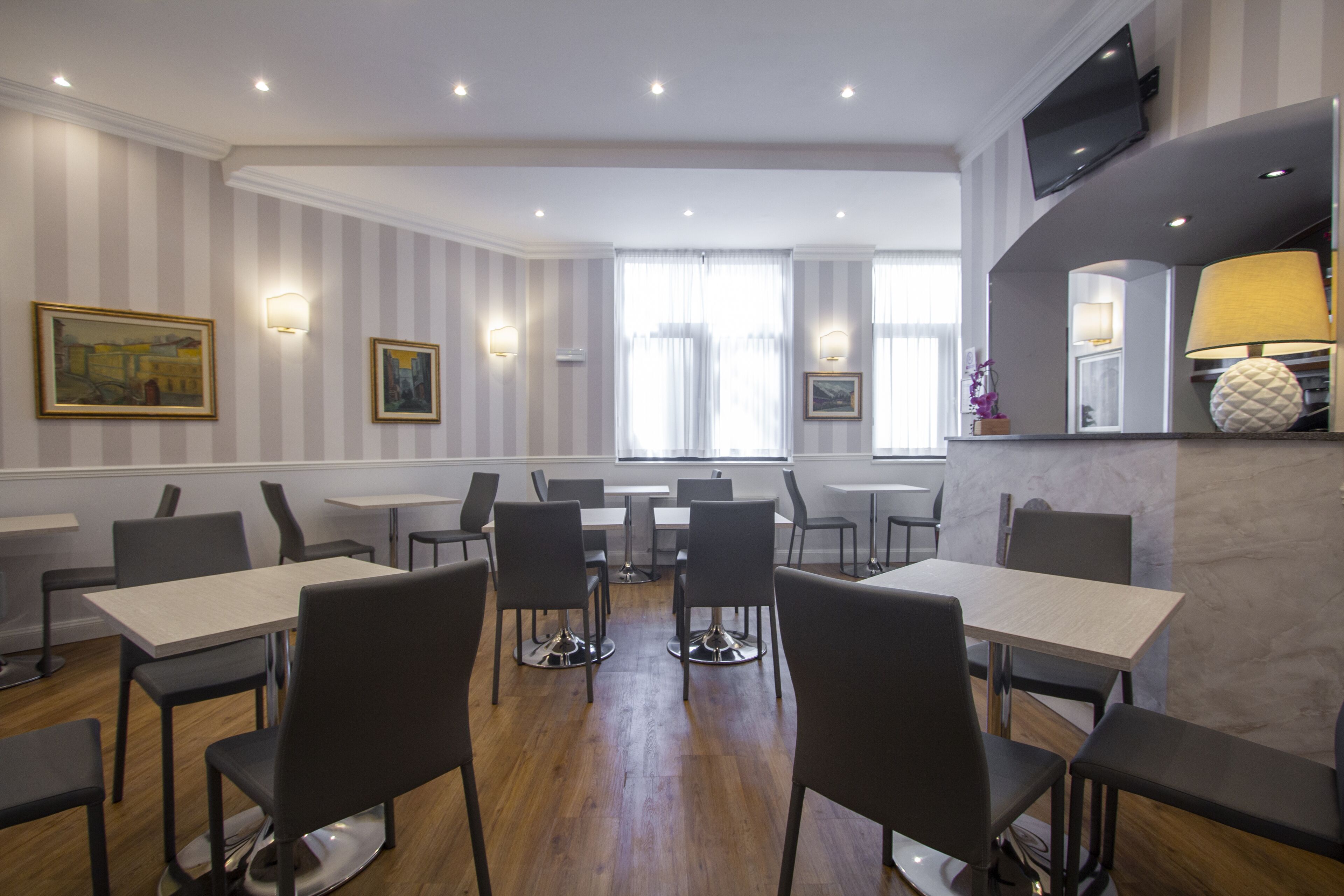 A modern dining area with striped walls, multiple tables, and chairs.