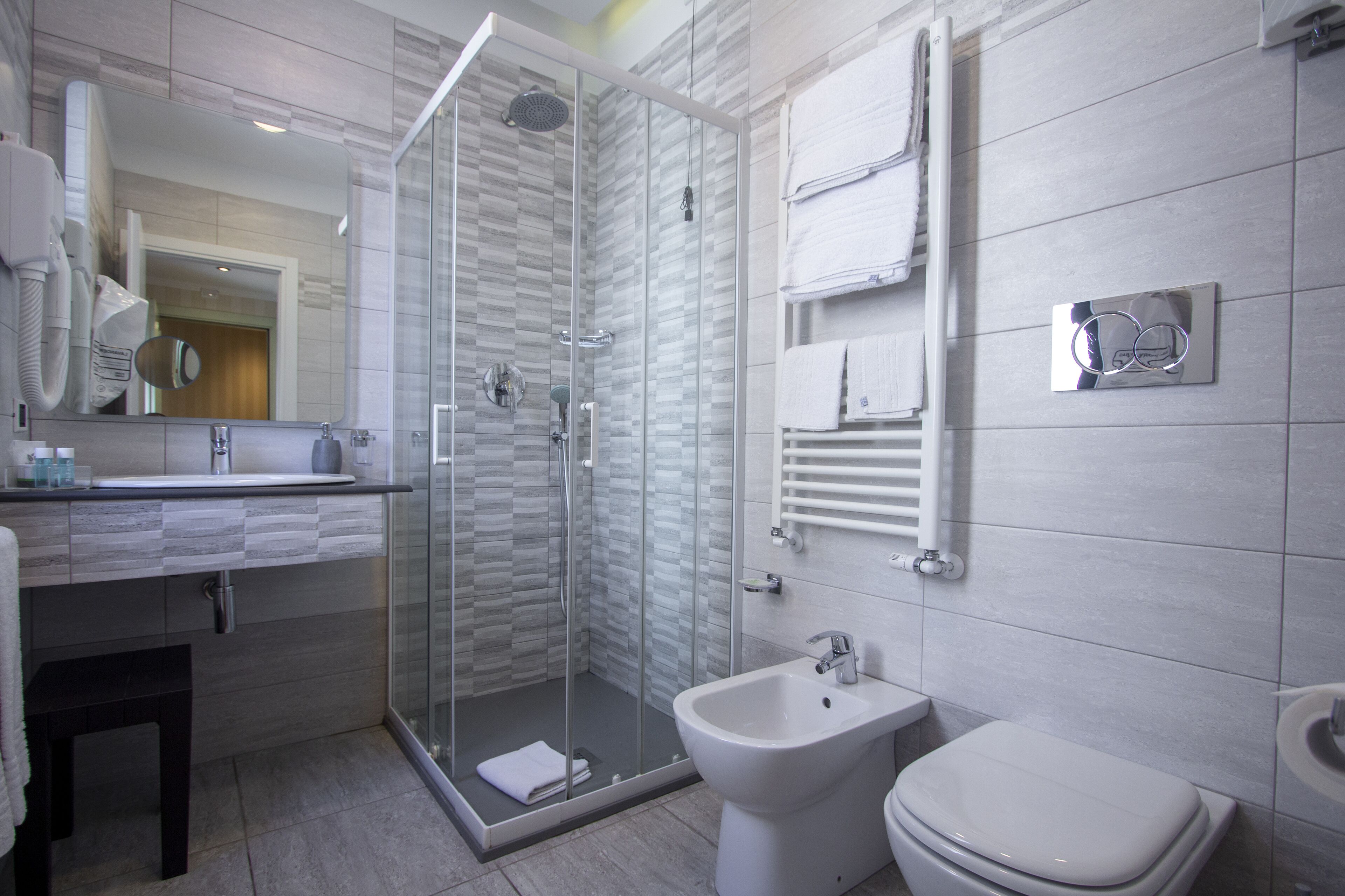 Une salle de bain moderne dotée d’une douche à parois de verre, d’un bidet et de toilettes.