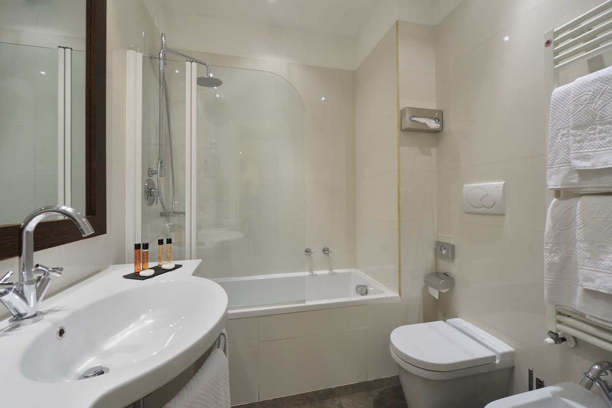 Une salle de bain moderne avec une douche à parois de verre, un lavabo blanc et des toilettes.