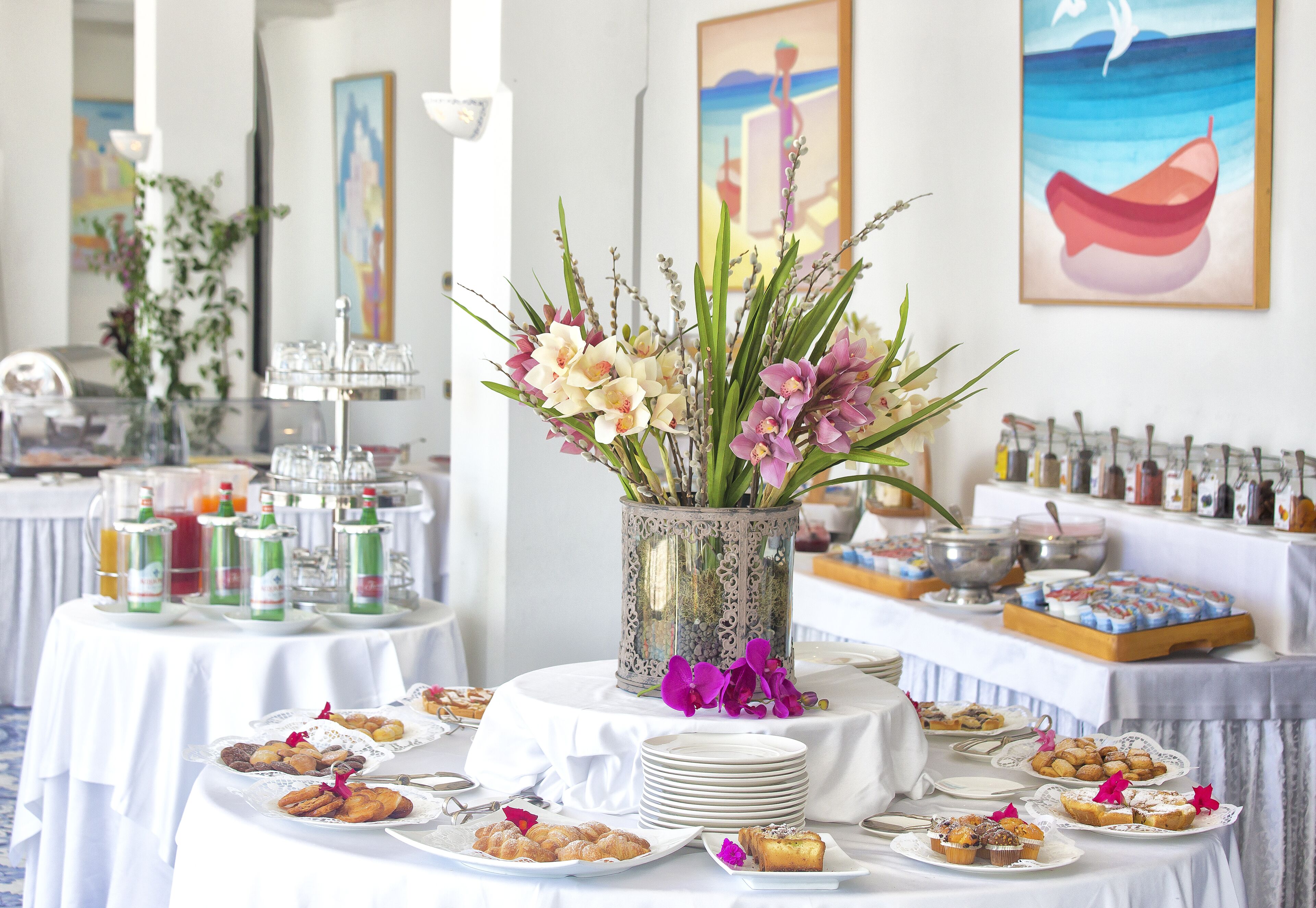 Une table de buffet garnie de divers plats et un vase décoratif rempli de fleurs.