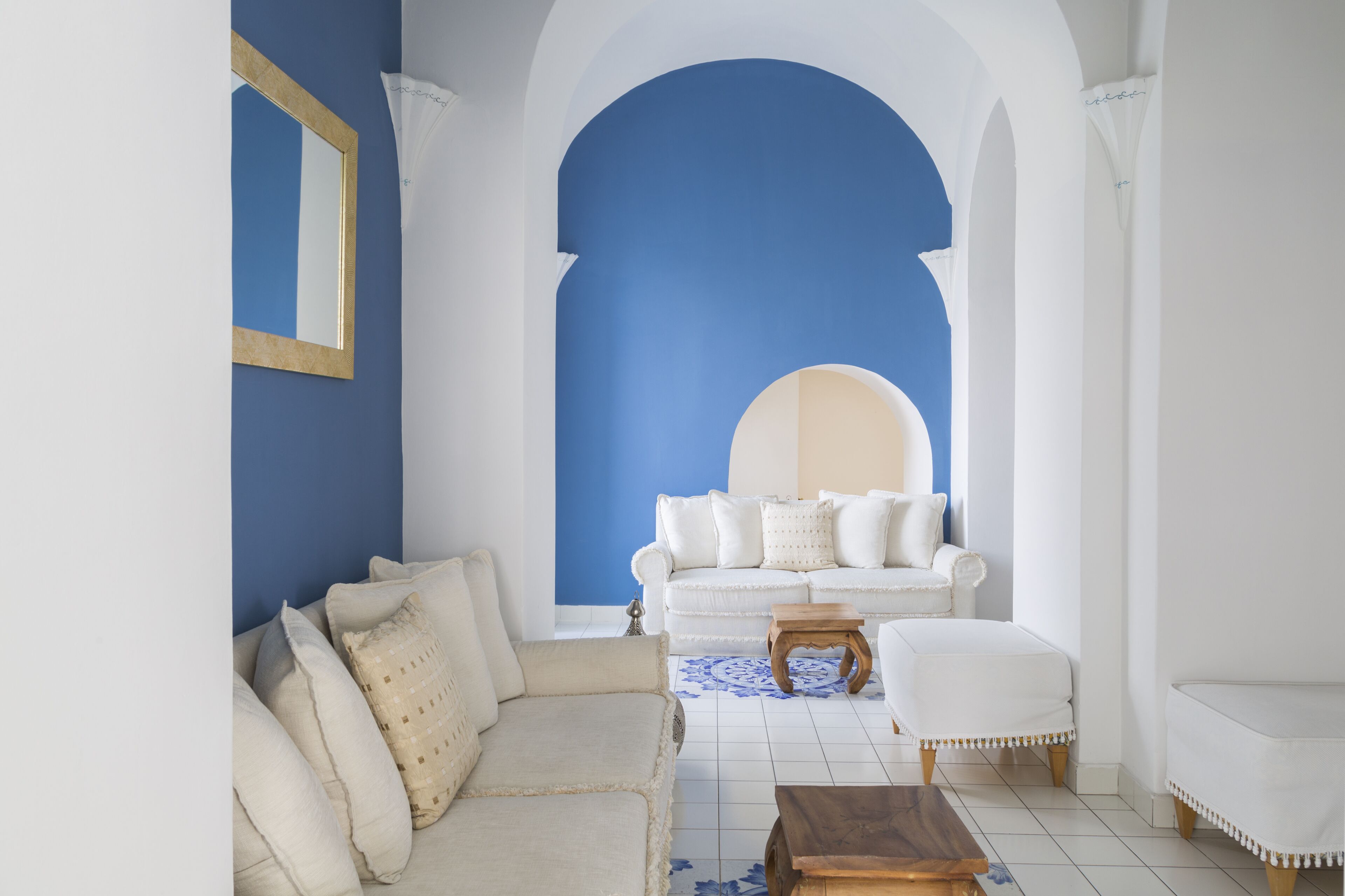 A living room with a white sofa, a wooden coffee table, and a patterned rug.