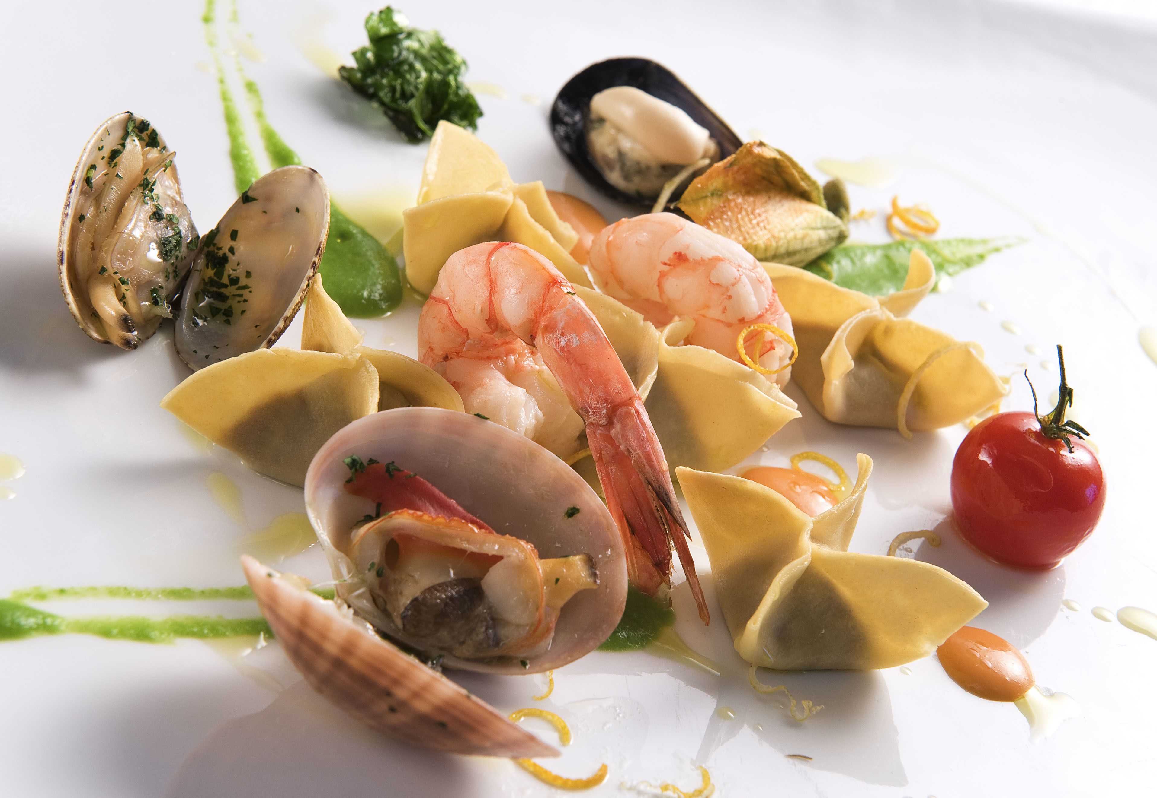 A seafood dish with mussels, shrimp, and clams on a white plate.