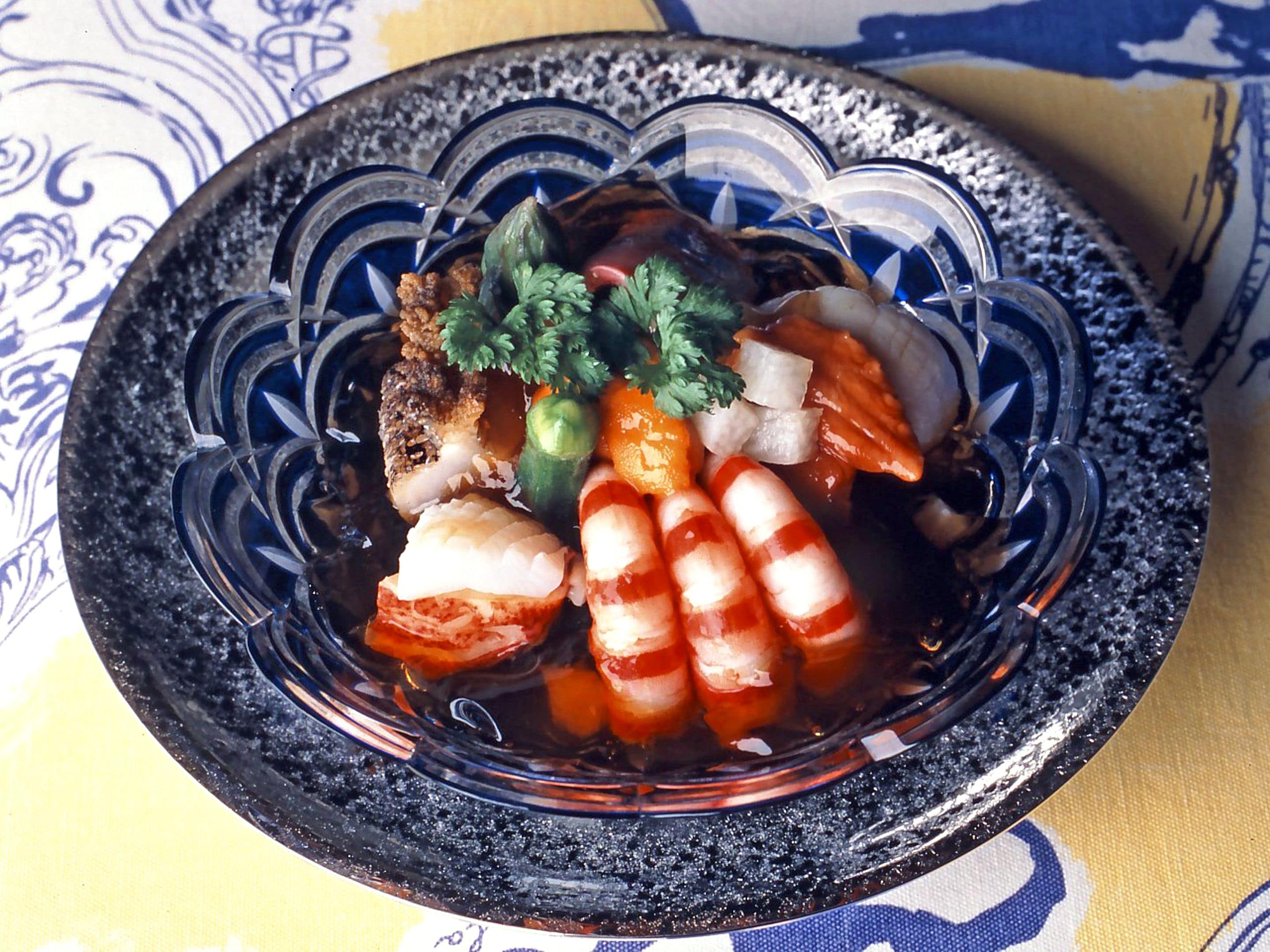 Un tazón de sushi con diferentes ingredientes y guarniciones.