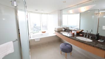 A modern bathroom with a glass shower enclosure, a large vanity with two sinks, and a large mirror.