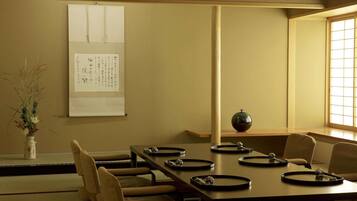 A traditional Japanese meeting room with tatami mats, a low table, and a shoji screen.