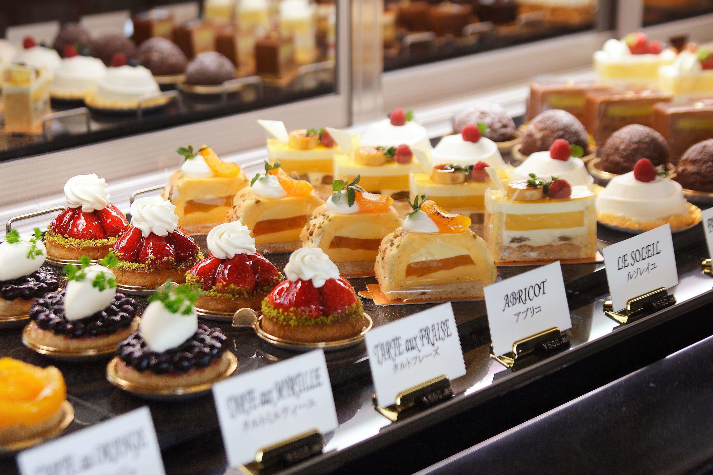 A display of various desserts with labels indicating names and prices.
