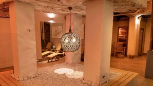 Uma área de spa com um candeeiro decorativo, uma vela e cadeiras de descanso.