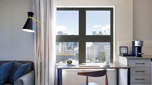 Una cocina moderna con vistas a la ciudad, un escritorio con una computadora portátil y una silla.