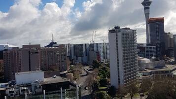 Un paisaje urbano con una torre destacada, edificios modernos y un área de estacionamiento.