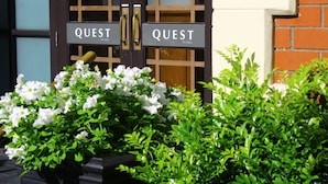 Una puerta con dos letreros que dicen 'QUEST On Eden'.