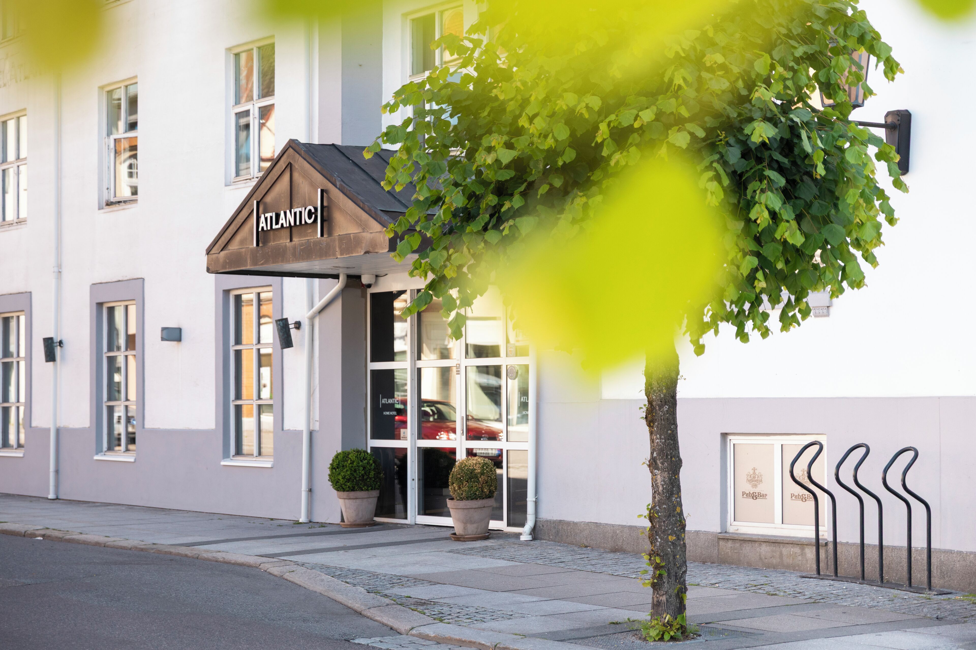 A building with a sign reading "ATLANTIC" and a tree in front.