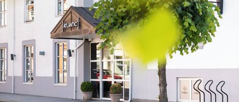 A building with a sign reading "ATLANTIC" and a tree in front.
