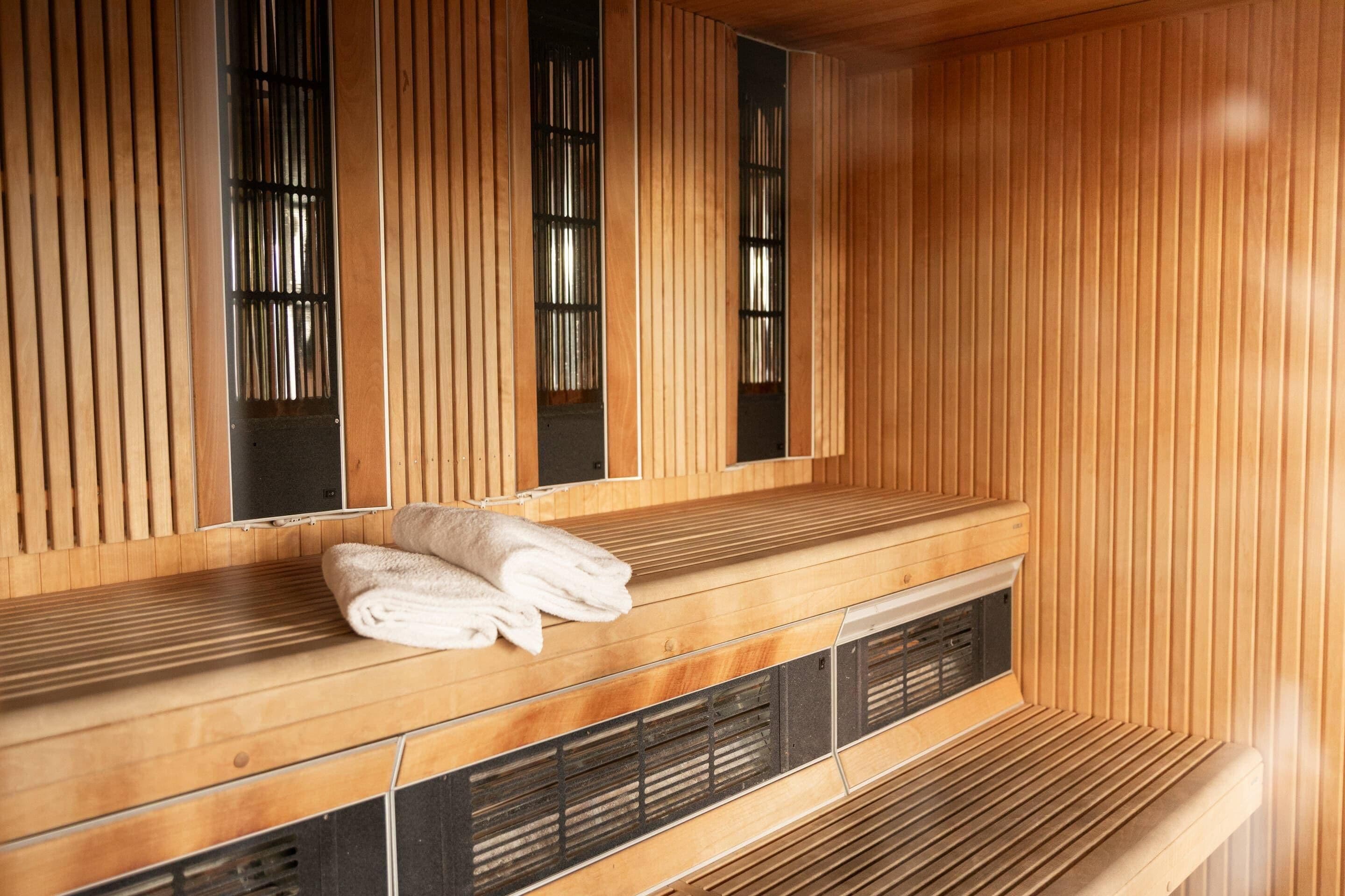 Una sauna con bancos de madera y una toalla sobre uno de ellos.