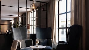 Una habitación moderna con sofá, sillones, una mesita y una lámpara.