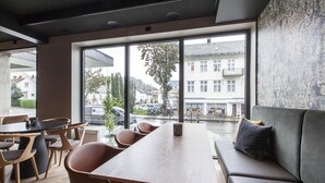 A modern interior with a wooden table, brown chairs, and a grey sofa. - Scandic Victoria Floro (Floro)