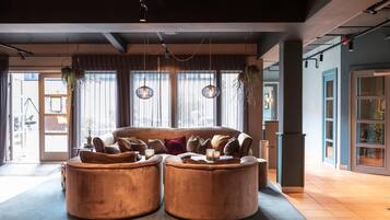 A modern interior with a sofa set, hanging plants, and pendant lighting.