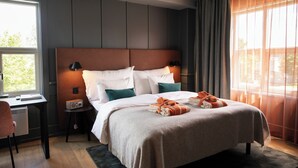 Una habitación de hotel moderna con una cama grande, un escritorio y una silla.