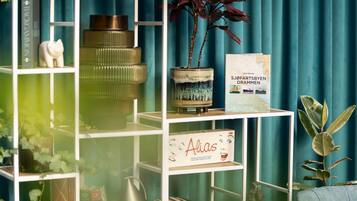 A bookshelf with books, a map, and a small plant.