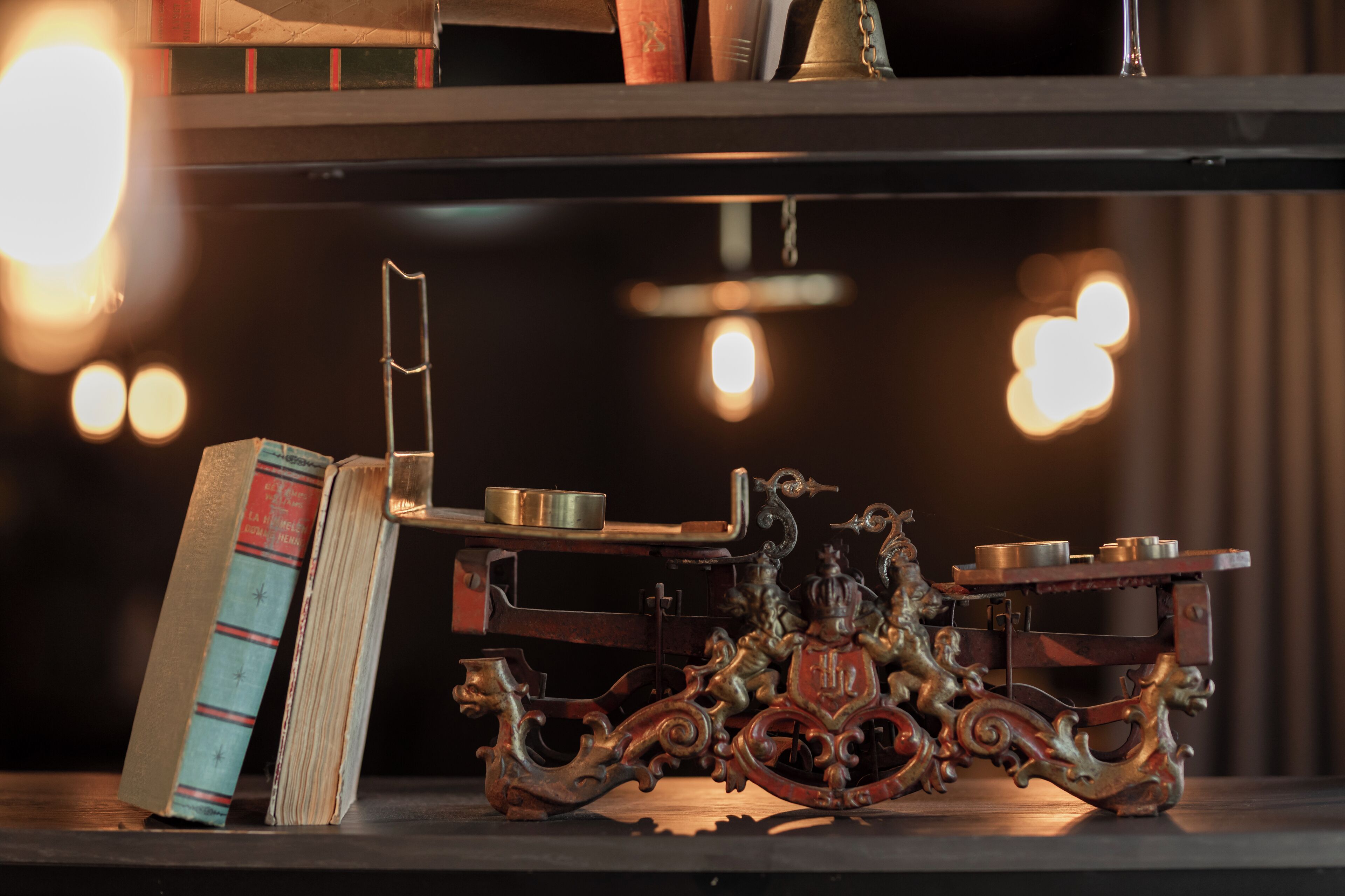 A shelf with books and a decorative metal stand.