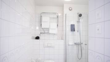 Un baño moderno con inodoro, lavamanos y ducha.