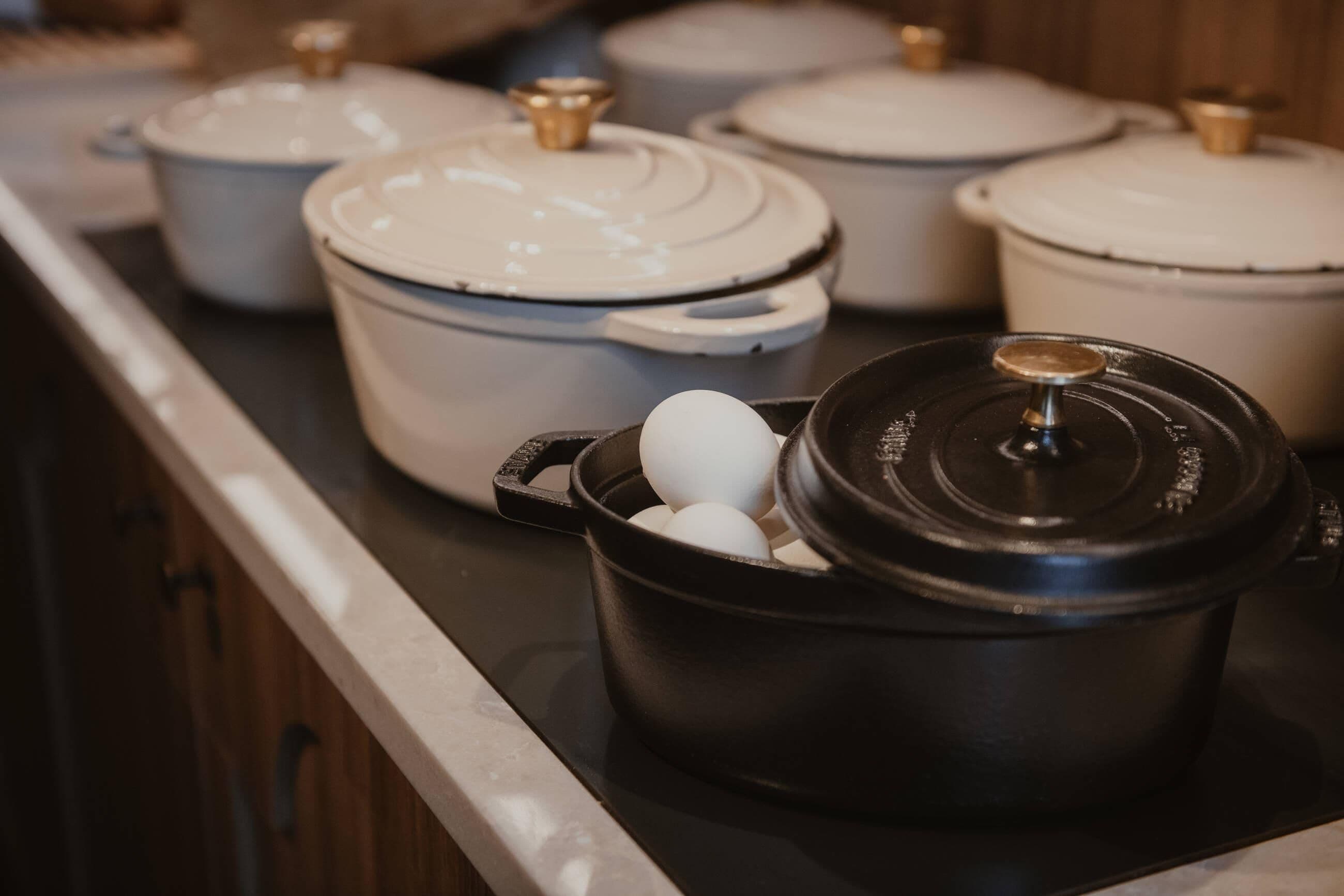 A kitchen with several pots and pans on a stove.
