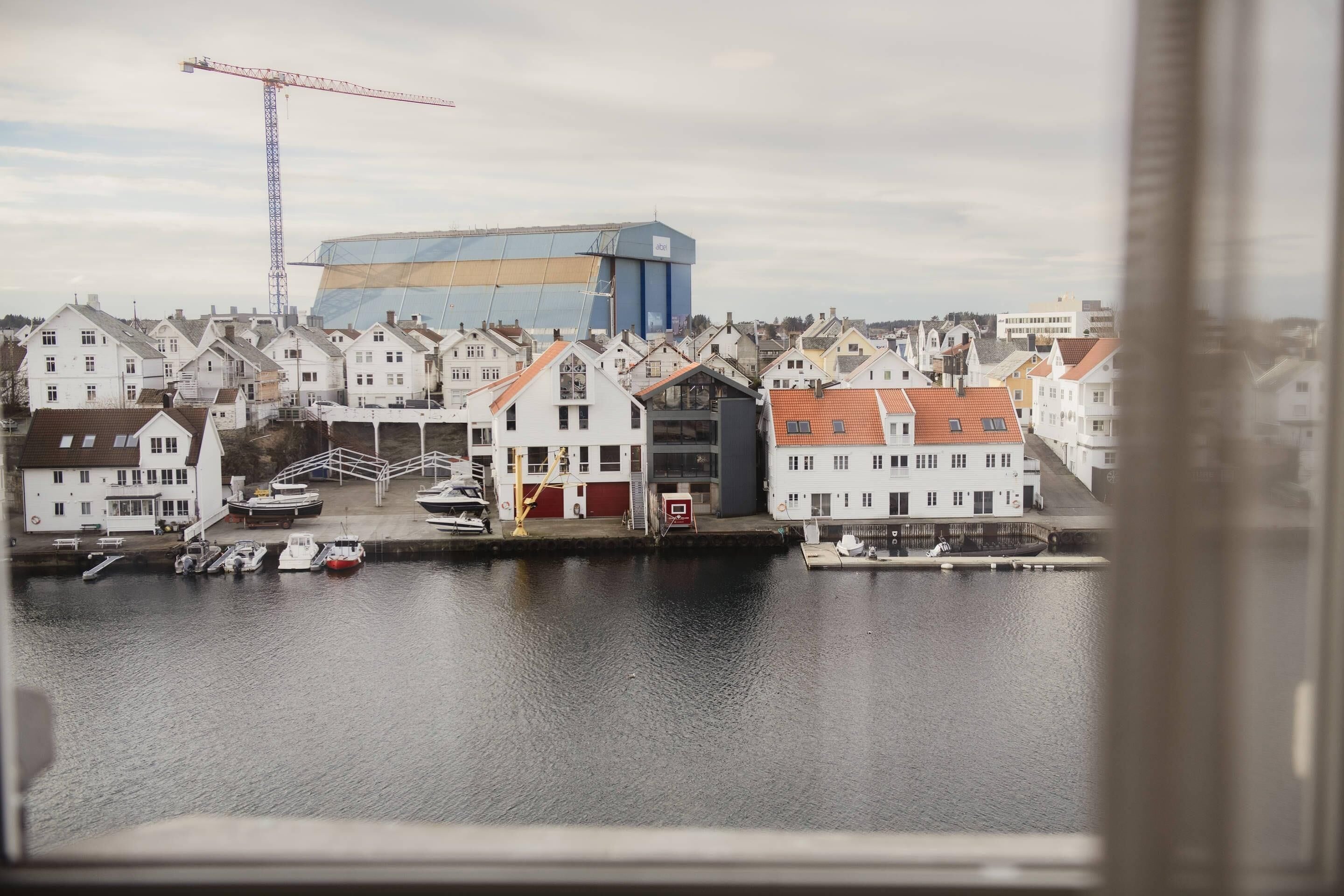 A waterfront view with buildings, a crane, and boats.