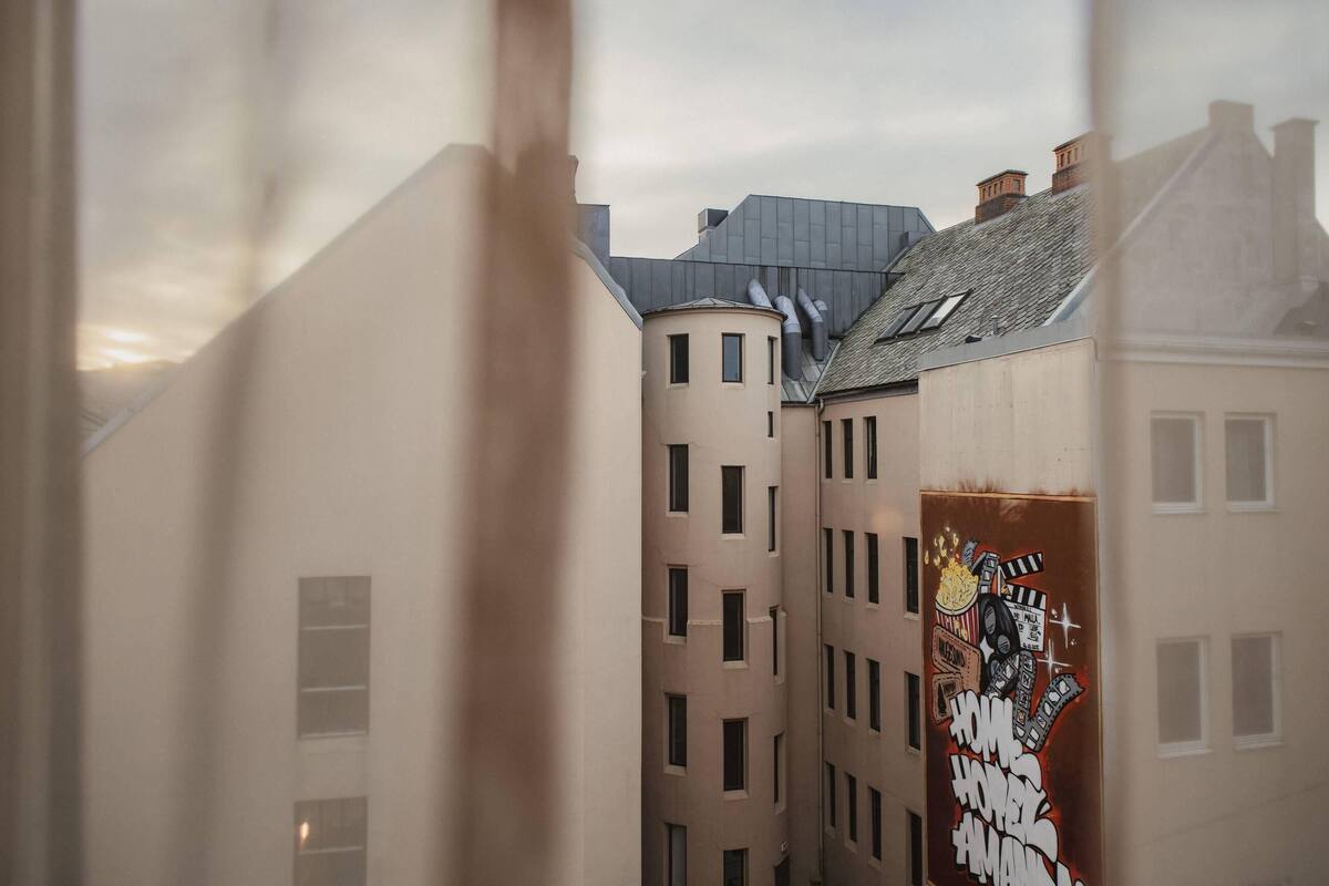 A view of a building with multiple windows and a mural on the side.