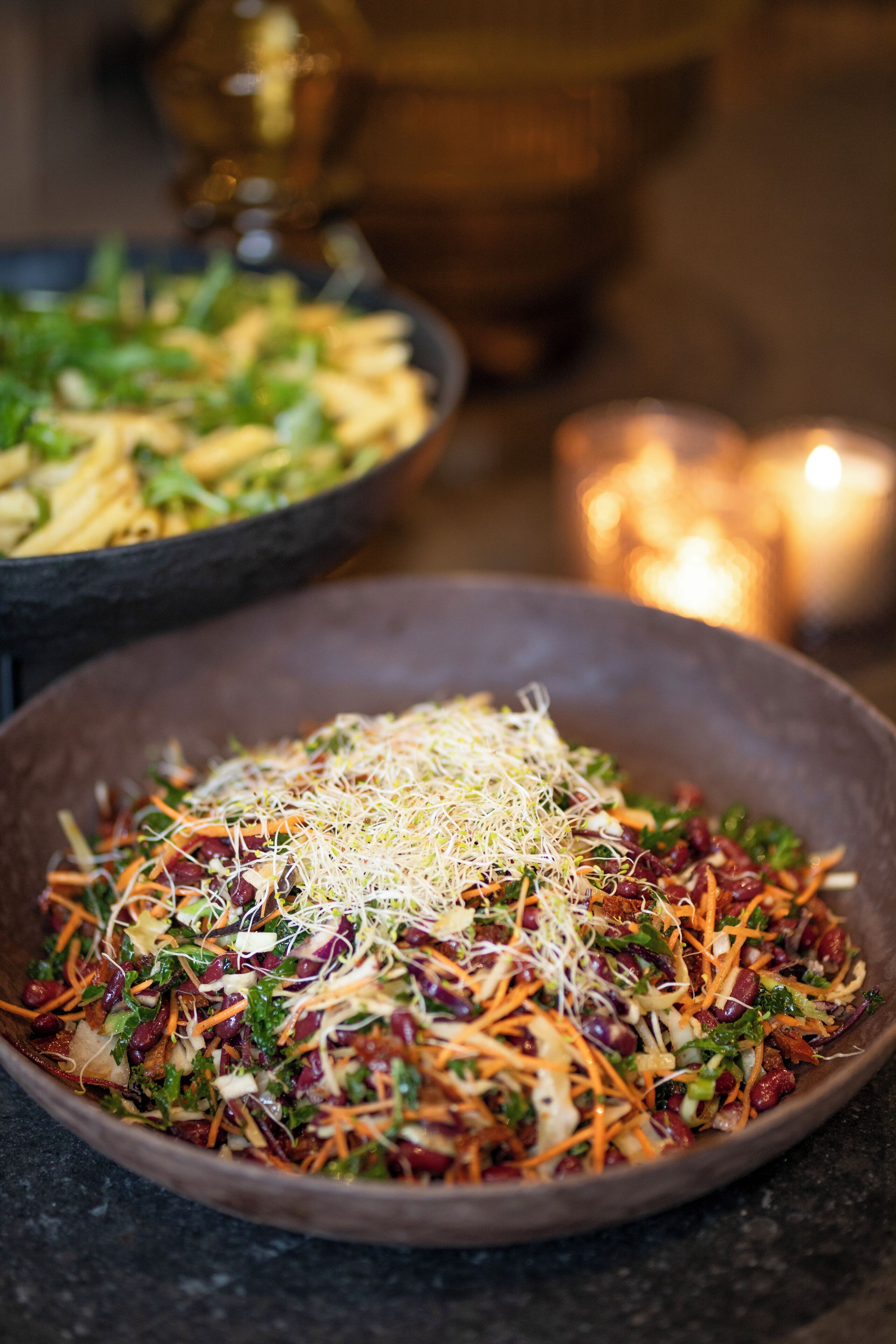 A bowl of salad with various vegetables and shredded cheese.
