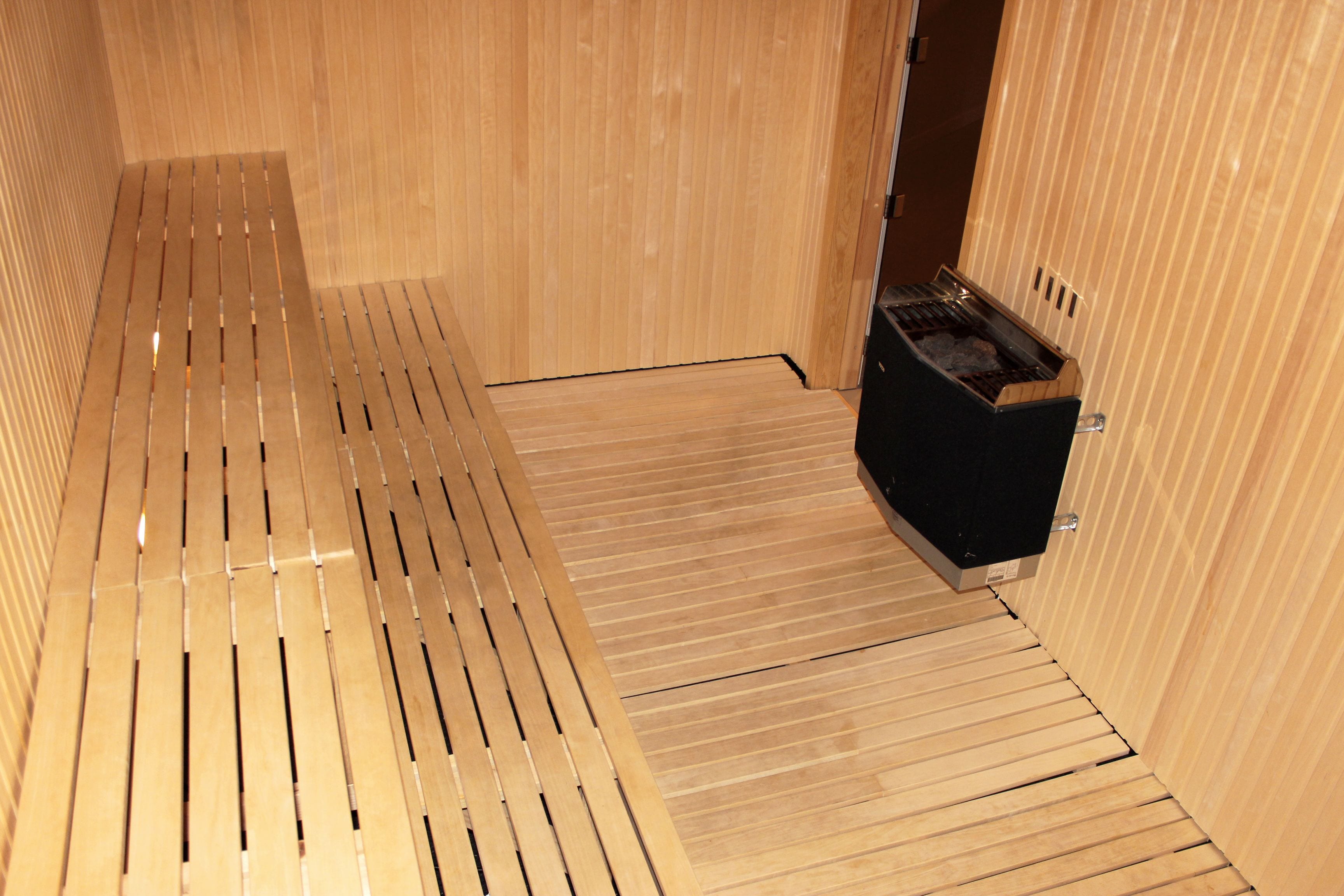 A wooden interior with a bench and a black cabinet.