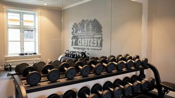 A gym with a wall-mounted dumbbell rack and a motivational quote.