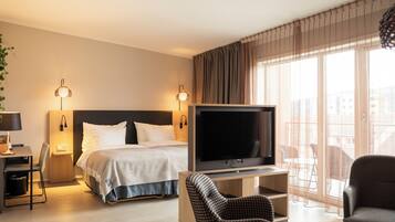A hotel room with a bed, a TV, a desk, and a chair.