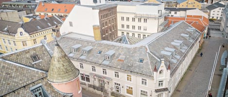 Un edificio histórico con un patio central, una torre del reloj y vista al mar.
