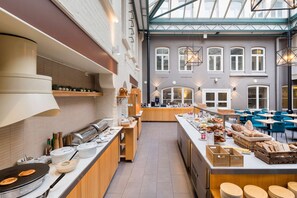 A spacious café with a long counter, various food items, and seating areas. - Best Western Plus Hotel Bakeriet (Trondheim)