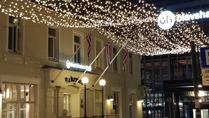 A building with a bakery sign, string lights, and flags. - Best Western Plus Hotel Bakeriet (Trondheim)
