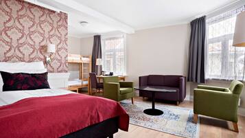 Una habitación de hotel con cama, escritorio, sofá y sillón.