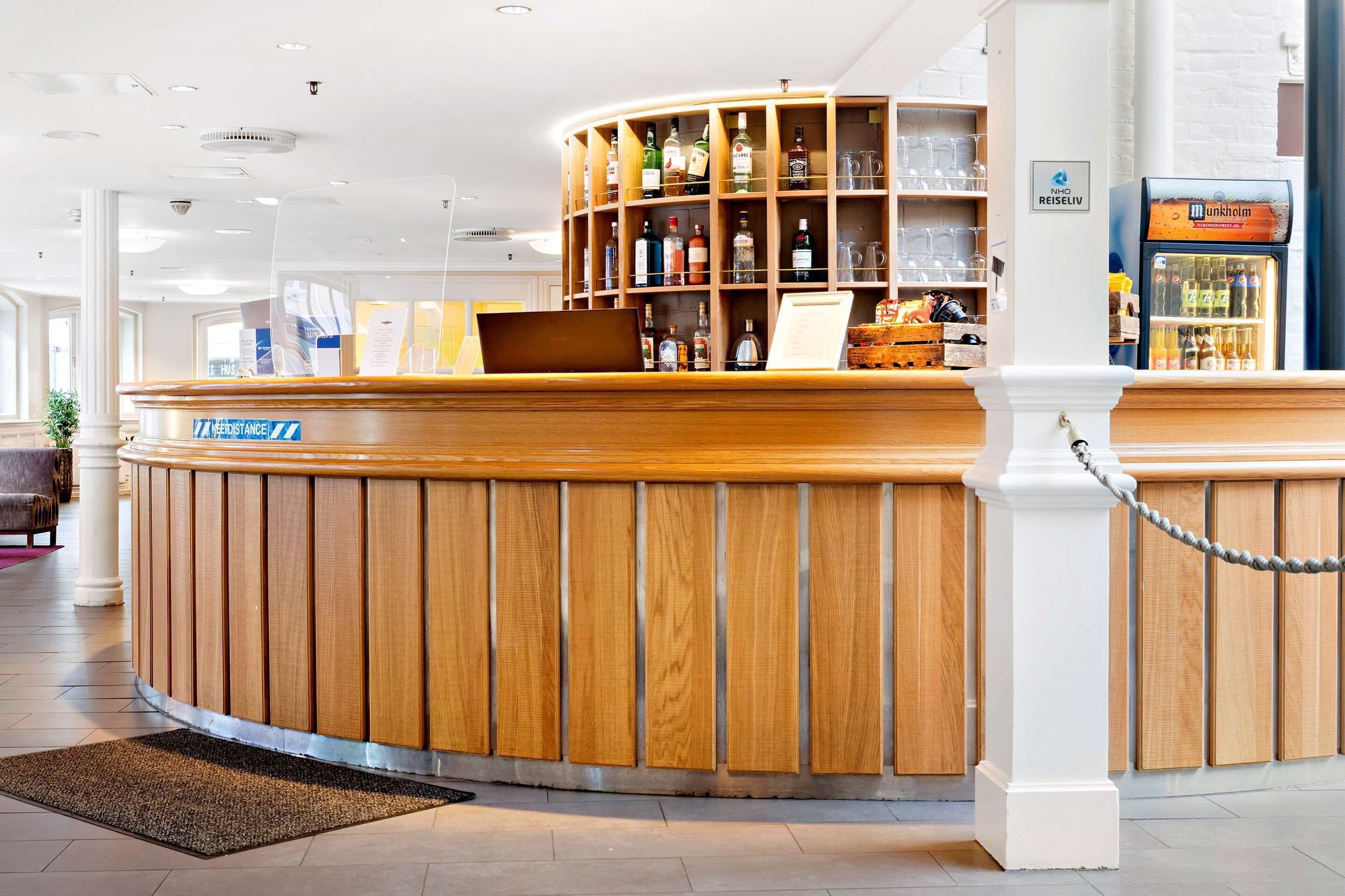 Ein Empfangsbereich mit Holzbeschreibungstresen, einer Glastheke und einer Minibar.