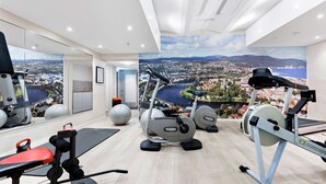 A gym with cardio machines, weight equipment, and a large mirror reflecting the view. - Best Western Plus Hotel Bakeriet (Trondheim)