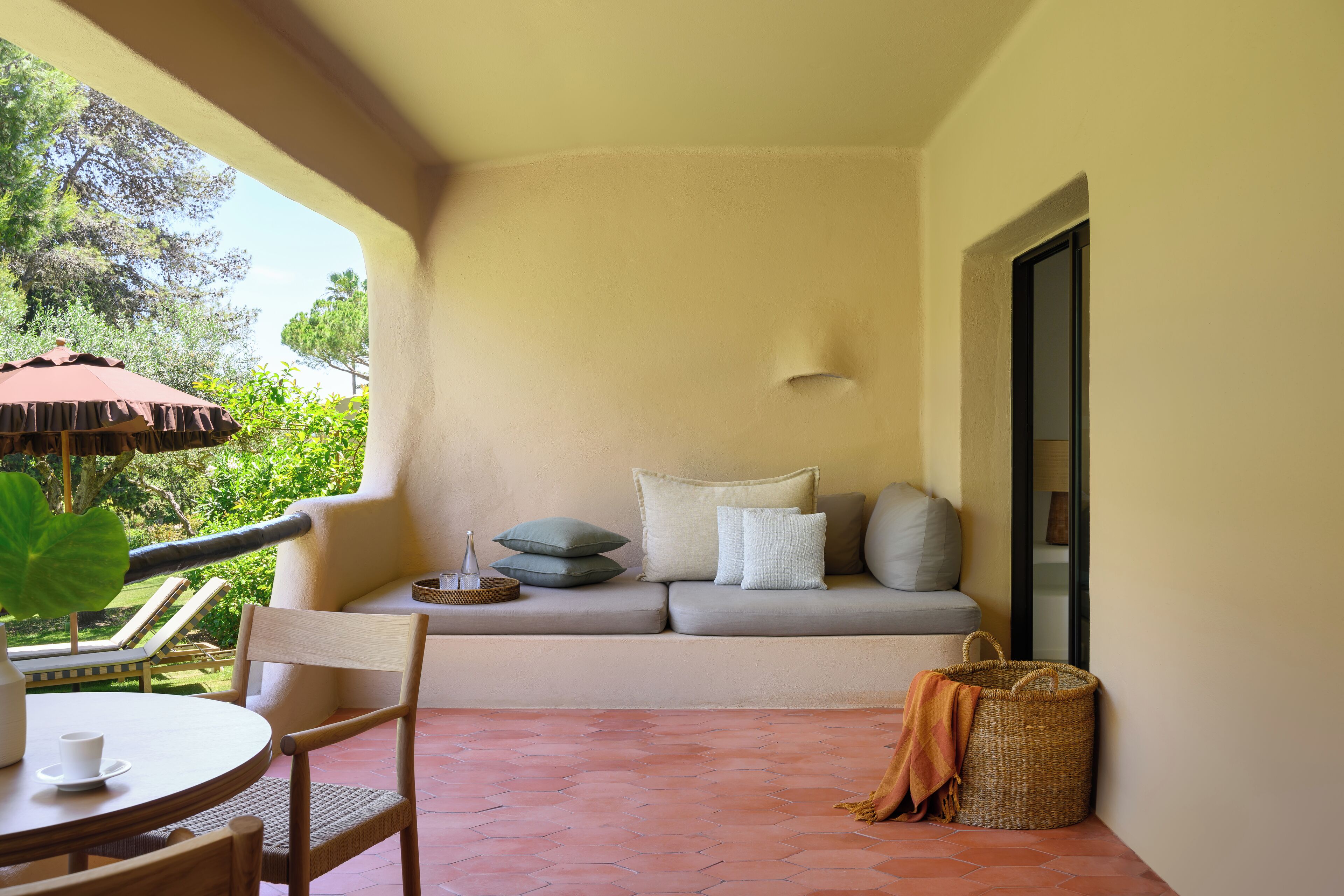 Ein gemütlicher Balkon mit einer Couch, einem Tisch und Stühlen.