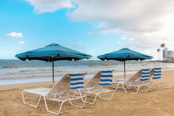 Beach nearby, white sand, beach umbrellas, beach towels at Hampton Inn & Suites San Juan