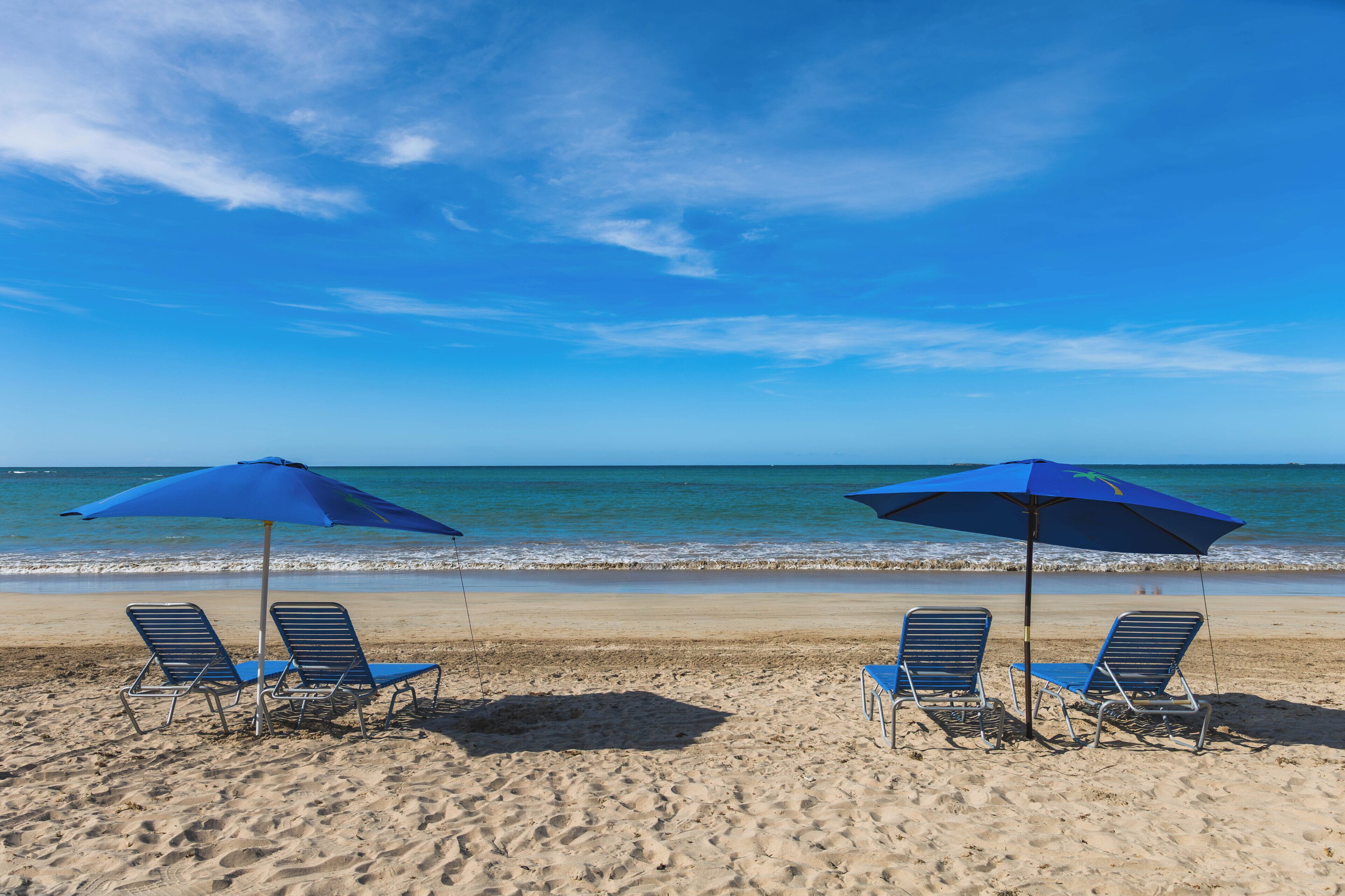 Una playa cerca, arena blanca, sombrillas, toallas de playa