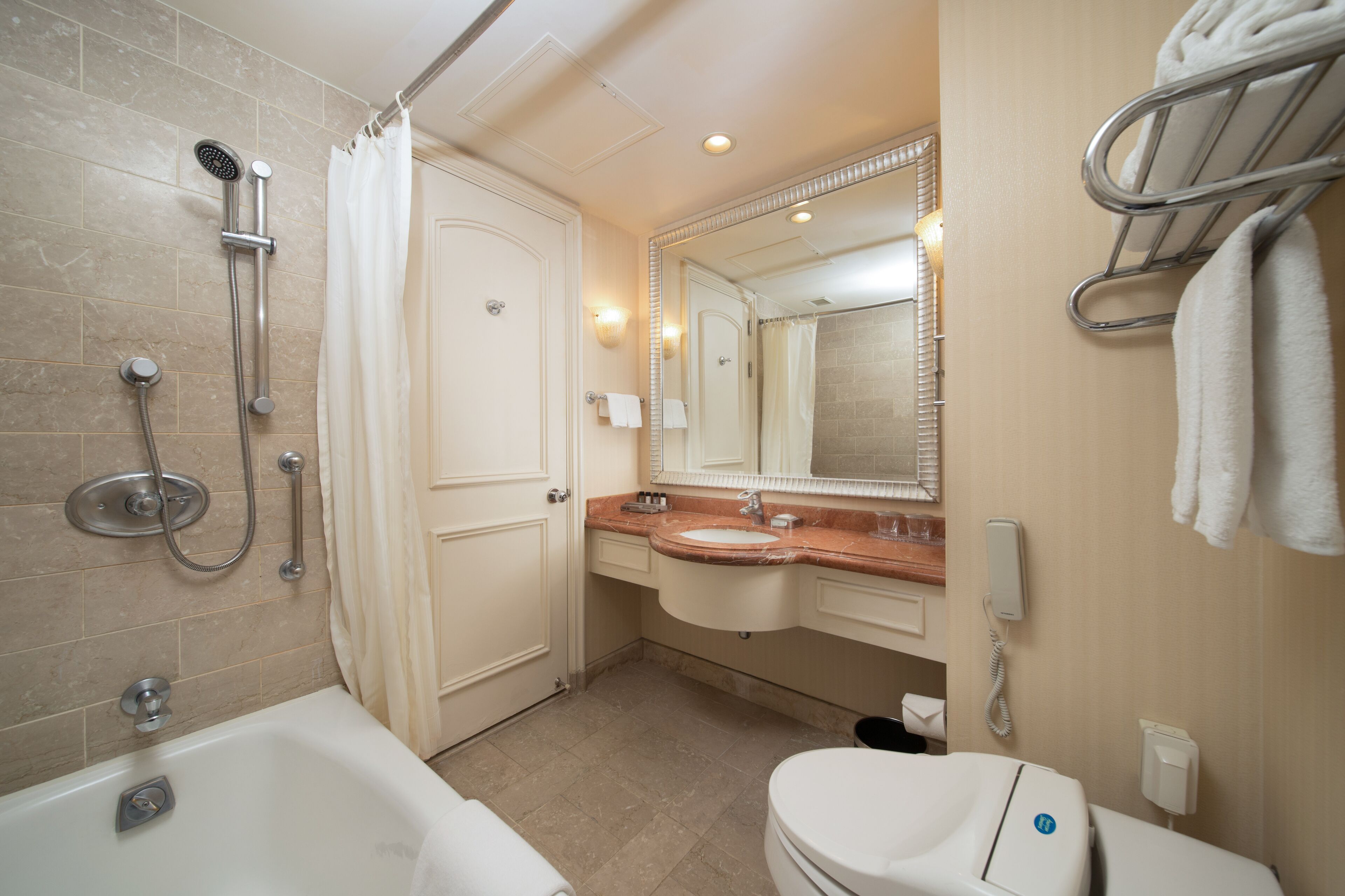 Baño con bañera, lavabo, inodoro, ducha y toallero.