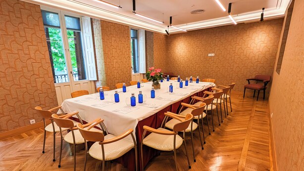 A conference room with a long table, chairs, and a vase of flowers. - Hotel Ópera (Madrid)
