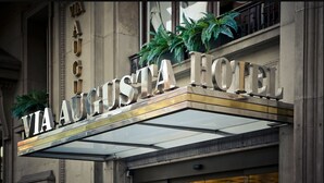 Exterior de l'Hotel Via Augusta, amb un cartell ben visible i una entrada de vidre.
