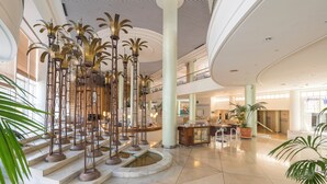 A spacious lobby with a central fountain, multiple levels, and modern decor.
